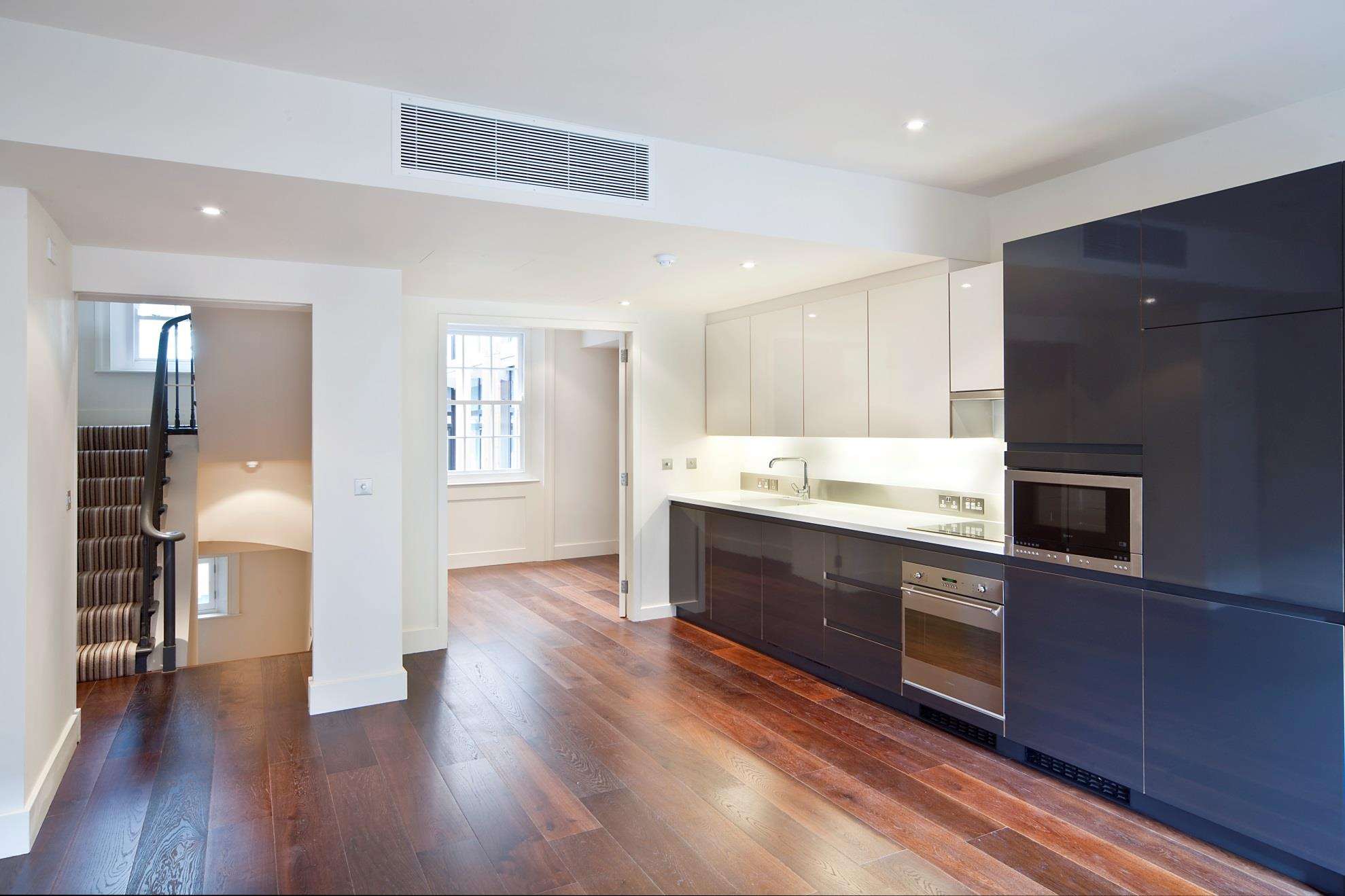 A completed apartment kitchen at New Bond Street with a gloss island unit.