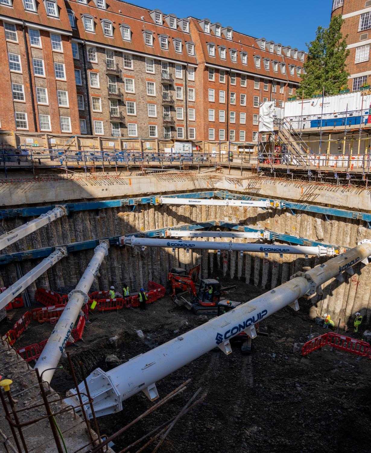 Double-storey basement excavation at Lucan Place, with raking steel props spanning the open box and a tower crane above.