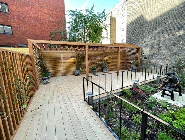 The completed courtyard garden at Princes Square with a timber pergola and mature tree retained.
