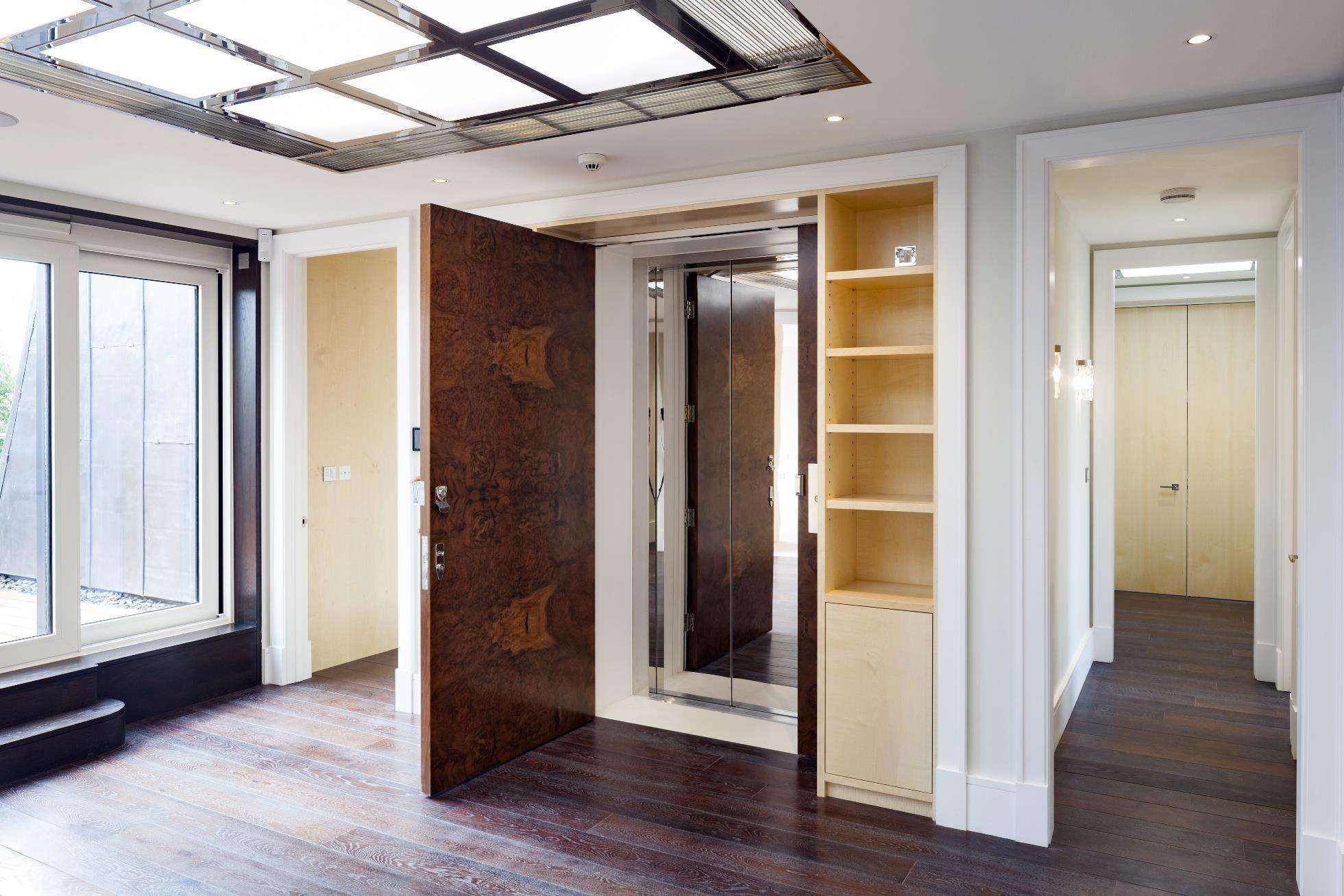 The entrance hall at One Highgate with chequerboard marble flooring and a chandelier.
