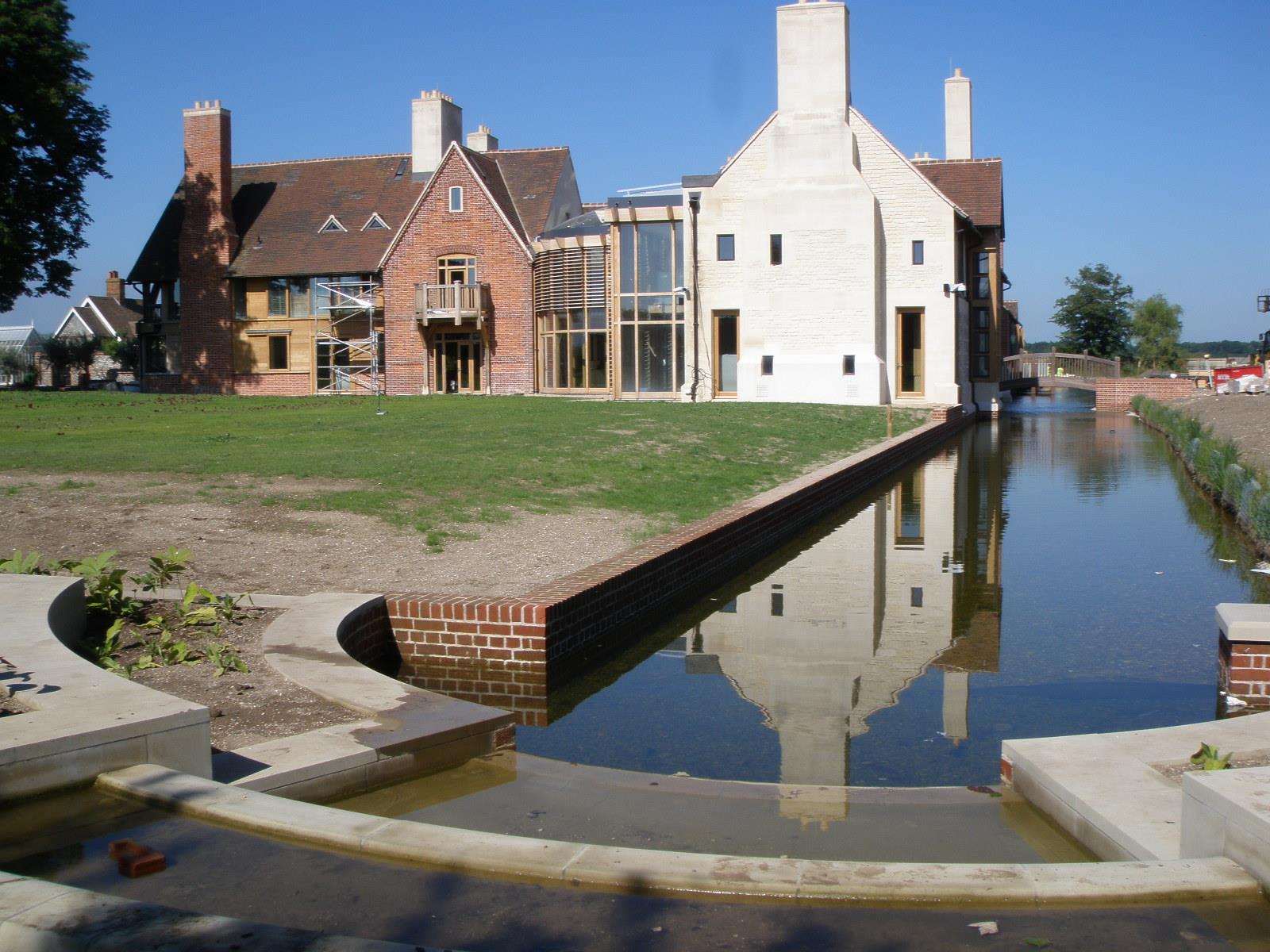 Huttons Farm reflected in the lake that runs along the front of the estate.
