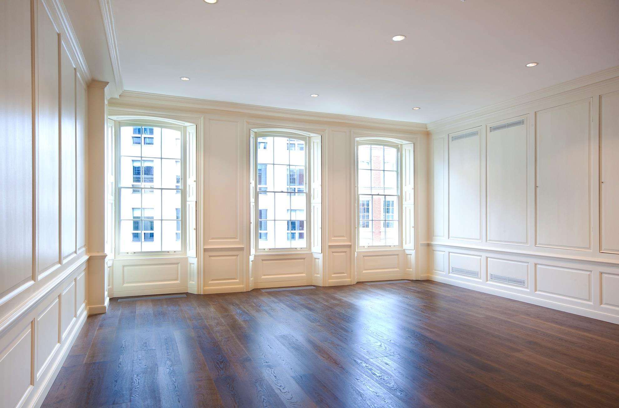 A panelled reception room with arched sash windows in the completed Mayfair apartments.